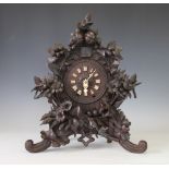 An early 20th century and later Black Forest carved wood wall bracket clock,