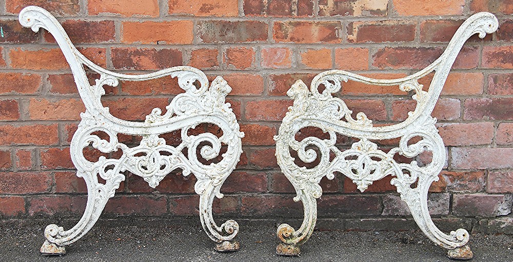 A pair of Victorian cast iron garden bench ends, cast with lions heads,