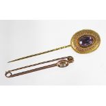 An amethyst set tie pin, the oval amethyst within wirework surround, all set in yellow metal,