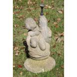A reconstituted stone garden fountain, modelled with a cherub and a fish on circular base,