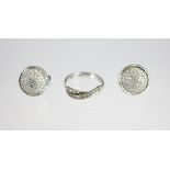 A pair of diamond set, white gold earrings, each designed as a circular convex panel,