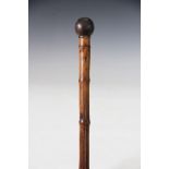 An Edwardian bamboo walking cane with cast iron ball handle and core, 1900gms approx,