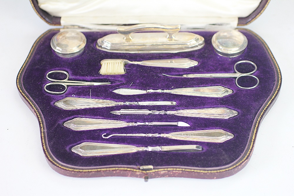 A cased silver manicure set, 'CD' London 1916, comprising; buffers, jars, tools, scissors, - Image 2 of 2