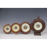 Four early 20th century barometers, including two with rop twist borders, largest 31cm,