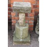 A reconstituted stone three section bird bath, with square top and circular column,