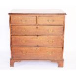 A George III oak chest, of two short and three graduated long drawers, on bracket feet,