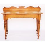 A Victorian golden oak serpentine side table, on turned legs,