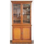 A Victorian carved oak bookcase, with two glazed doors enclosing adjustable shelves,