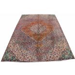 A Persian wool carpet, worked with different floral designs in a lozenge pattern,