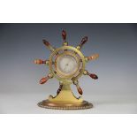 A Victorian brass ships wheel aneroid barometer, with banded orange agate wheel handles,