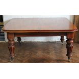 A Victorian mahogany extending dining table, the top with rounded corners and a moulded edge,