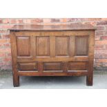 An early 18th century oak coffer, with two plank figured oak top, the front with eight panels,