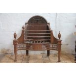 A George III style cast iron serpentine fire grate, with arched back plate, on tapered square legs,