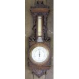 A Victorian carved oak aneroid barometer, with silvered dial signed by the retailer Charles W Coe,