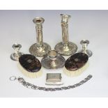 A silver vesta case, Sheffield 1935, two pairs of silver candlesticks, a white metal belt,