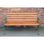 A Regency style cast iron garden bench, with wood slats and lion mask end supports,