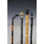 Four walking canes, comprising a Japanese carved and engraved bone cane with faux bamboo handle,