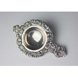 A Norwegian silver tea strainer by Thorvald Marthinsen, with cast scrolling foliate rim,