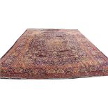 A Persian hand woven wool carpet, worked with a central medallion and corner spandrels,