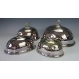 Four silver plated meat covers to include an engraved example, largest 35.