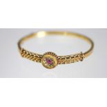 A lady's Victorian 15ct yellow gold bangle inset with rose cut diamonds and a central ruby,