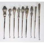 A collection of nine silver handled button hooks, Victorian and later,