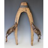 An oak yoke with attached leather straps and buckles,