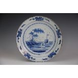 An English delft charger 18th century, painted in blue with a lone figure in a boat,