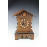 An oak cuckoo clock, Roman numeral dial and movement striking on a gong (as found),