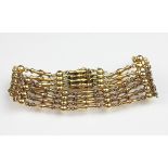 A yellow metal decorative link bracelet, the four row bracelet with integral clasp, stamped '15ct',