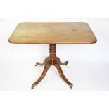 An early 19th century mahogany rectangular tilt top table, with turned column and tripod base,