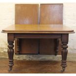 An early Victorian mahogany dining table, the top with a moulded edge on turned and fluted legs,