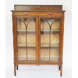 A 1920's oak display cabinet, with two astragal glazed doors and raised beaded back,