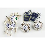 A Trifari brooch and earrings suite, designed as an enamelled strutting stylised horse, 6cm long,