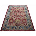 A Royal Agra wool carpet, floral spurs against a red ground with blue border, fringed,