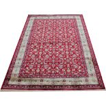 A Kashmir rug, worked with an all over foliate design against a red ground,