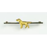 A gold bar brooch set with a spaniel, the polished bar set with a naturalistic standing spaniel,