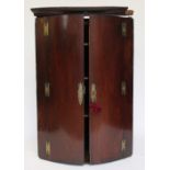 A George III mahogany bow front corner cabinet, with later escutcheons,