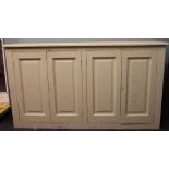 A painted four door kitchen / pantry cabinet, on plinth base,