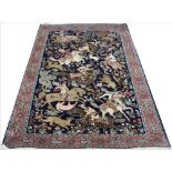 A Persian cotton Qum rug, worked with a hunting scene against a deep blue ground,