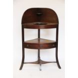 A George III mahogany corner wash stand, with drawer and undertier, on splayed legs,