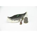 A novelty silver pin cushion in the form of a canoe,