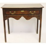 A George III oak and mahogany side table, with drawer and serpentine apron, on chamfered legs,