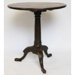 A George III provincial oak tilt top occasional table, with circular three section top,