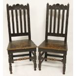 A pair of 18th century high back oak chairs, carved with tulips, with bar backs and solid seats,