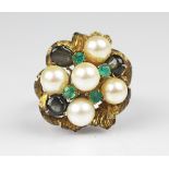 A 1970's dress ring, the bombe shaped yellow metal ring set with untested emeralds and pearls,