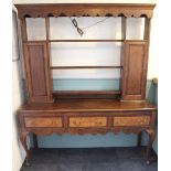 A George III style oak dresser, the plate rack with two panelled doors,