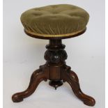 A Victorian carved rosewood adjustable piano stool, with upholstered seat,
