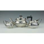 A silver three piece batchelors tea service, Fergenbaum & Son, Birmingham 1921, of half fluted form,