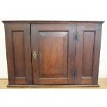 An 18th century and later oak hanging cupboard, with panelled door,